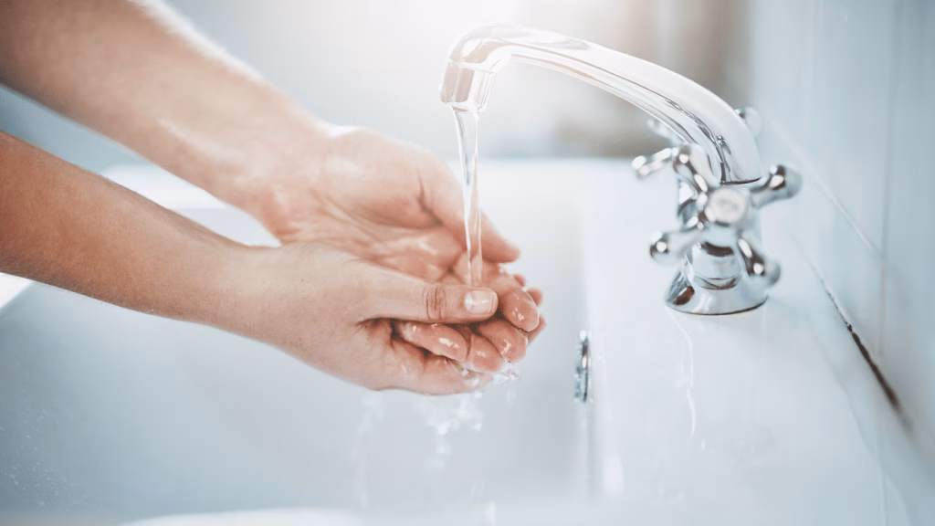 person washing hands under running water