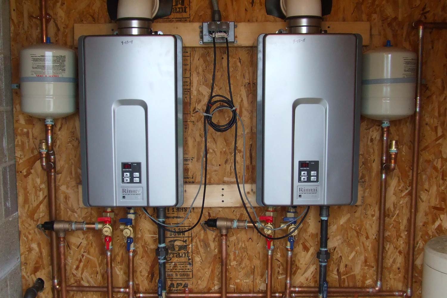 Rinnai water heaters mounted on wall in basement